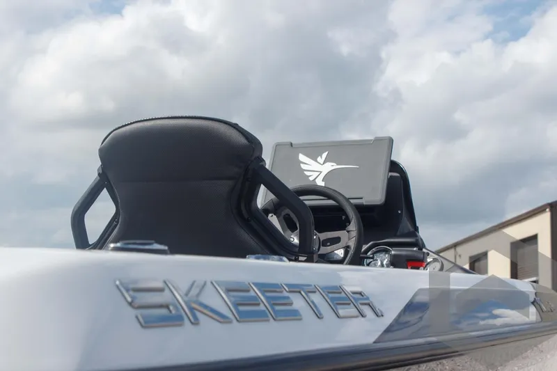 Slide: The Image of 2025 Skeeter ZXR 20 boat interior with steering wheel and console under cloudy sky. - 15