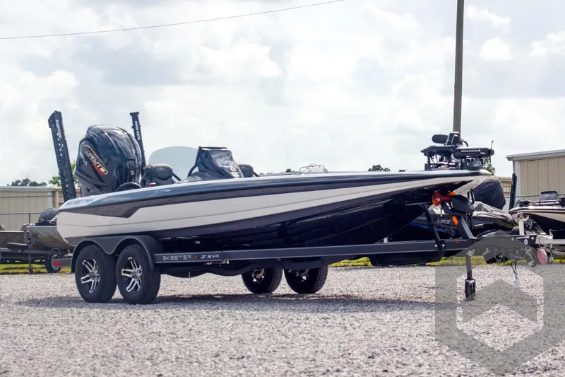 Slide: The Image of 2025 Skeeter ZXR 20 boat on trailer, parked outdoors on gravel. - 3