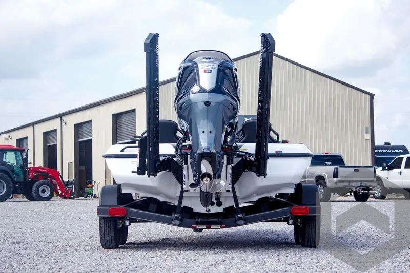 Slide: The Image of 2025 Skeeter ZXR 20 boat rear view, parked on gravel near industrial building. - 6