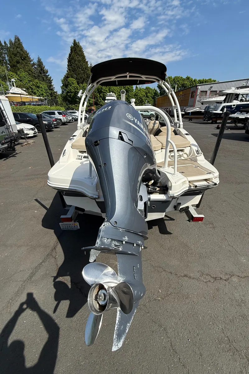 Slide: The Image of 2018 Chaparral 21 Deluxe H20 Ski and Fish boat with outboard motor, parked outdoors. - 11