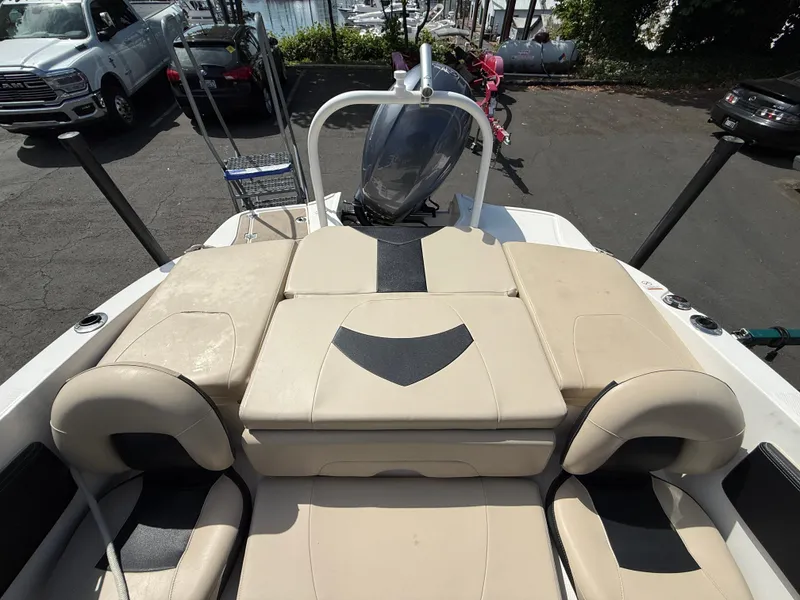Slide: The Image of 2018 Chaparral 21 Deluxe H20 Ski and Fish boat with beige seating, parked near water. - 9