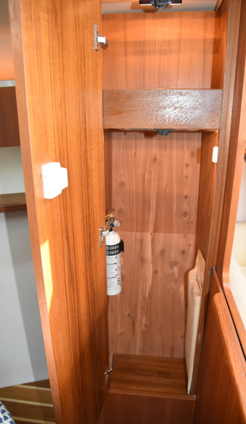 Slide: The Image of 2006 Tiara Yachts 36 Open interior wooden cabinet with fire extinguisher. - 11