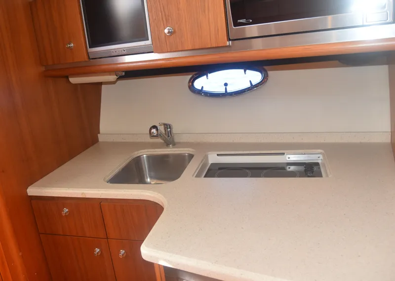 Slide: The Image of 2006 Tiara Yachts 36 Open kitchen with sink, stove, and wooden cabinetry. - 25