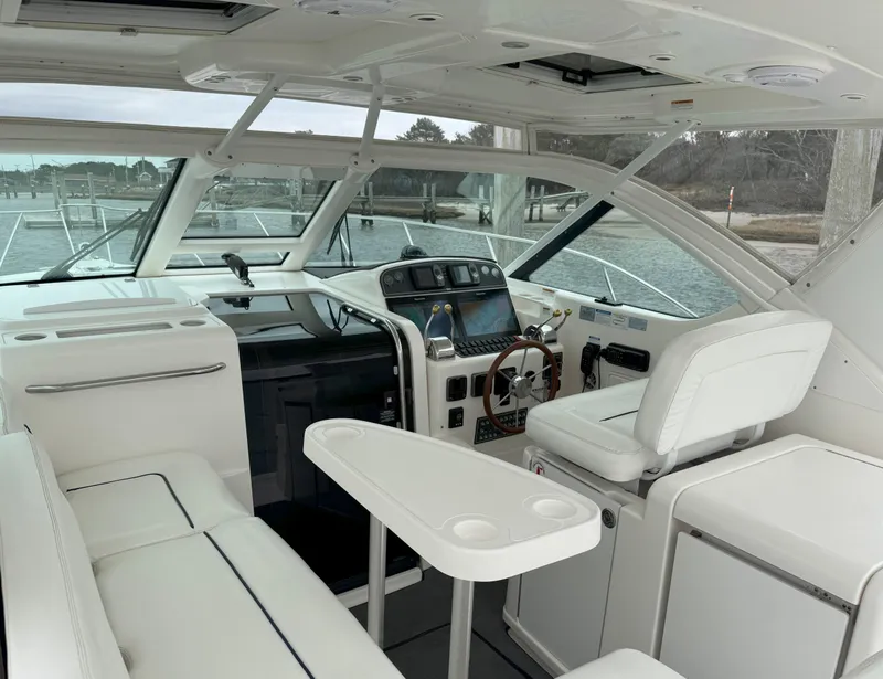 Slide: The Image of 2006 Tiara Yachts 36 Open interior with helm, seating, and table, docked by the water. - 6