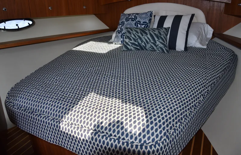 Slide: The Image of Cabin interior of 2006 Tiara Yachts 36 Open with patterned bedding and pillows. - 8