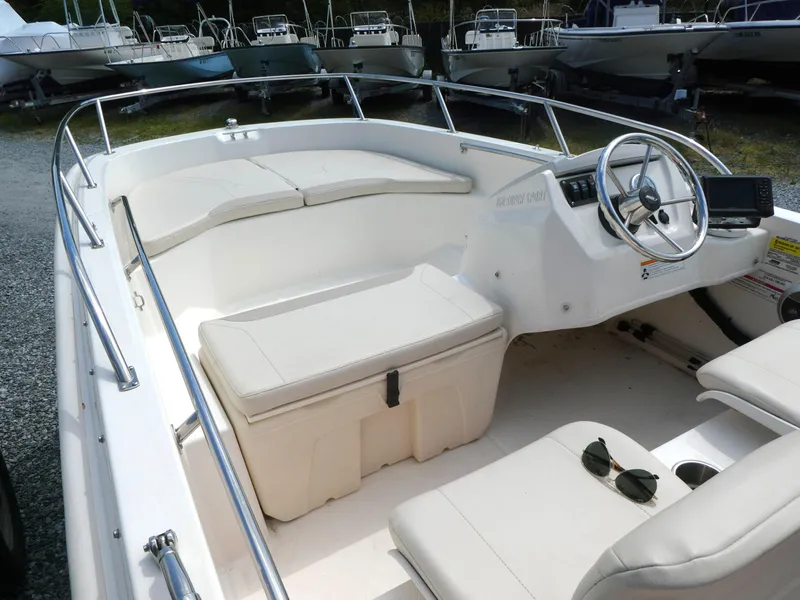 Slide: The Image of 2024 Boston Whaler 160 Super Sport boat interior with white seating and steering wheel. - 4