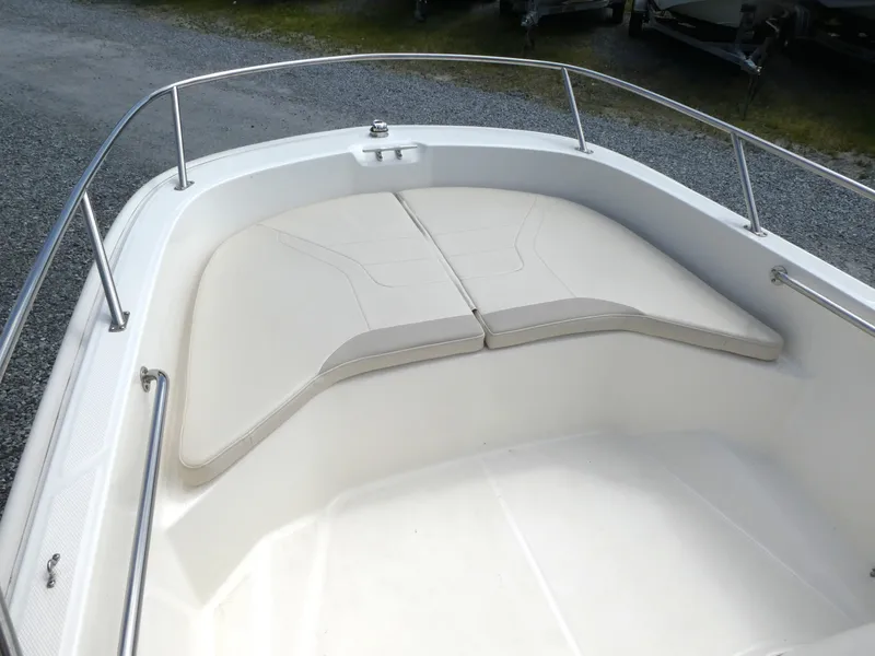 Slide: The Image of 2024 Boston Whaler 160 Super Sport boat with cushioned bow seating and stainless steel railing. - 6