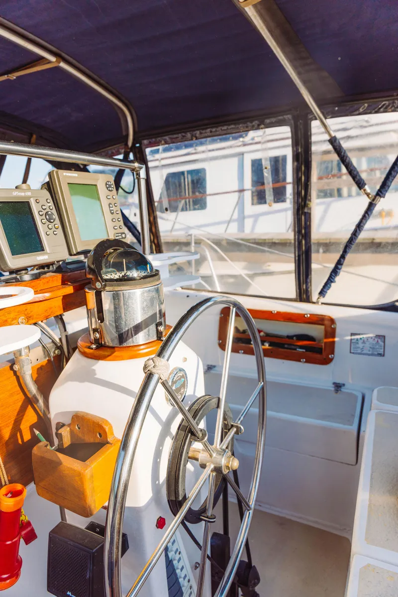 Slide: The Image of 1983 Morgan Out Island 41 yacht cockpit with steering wheel and navigation equipment. - 10