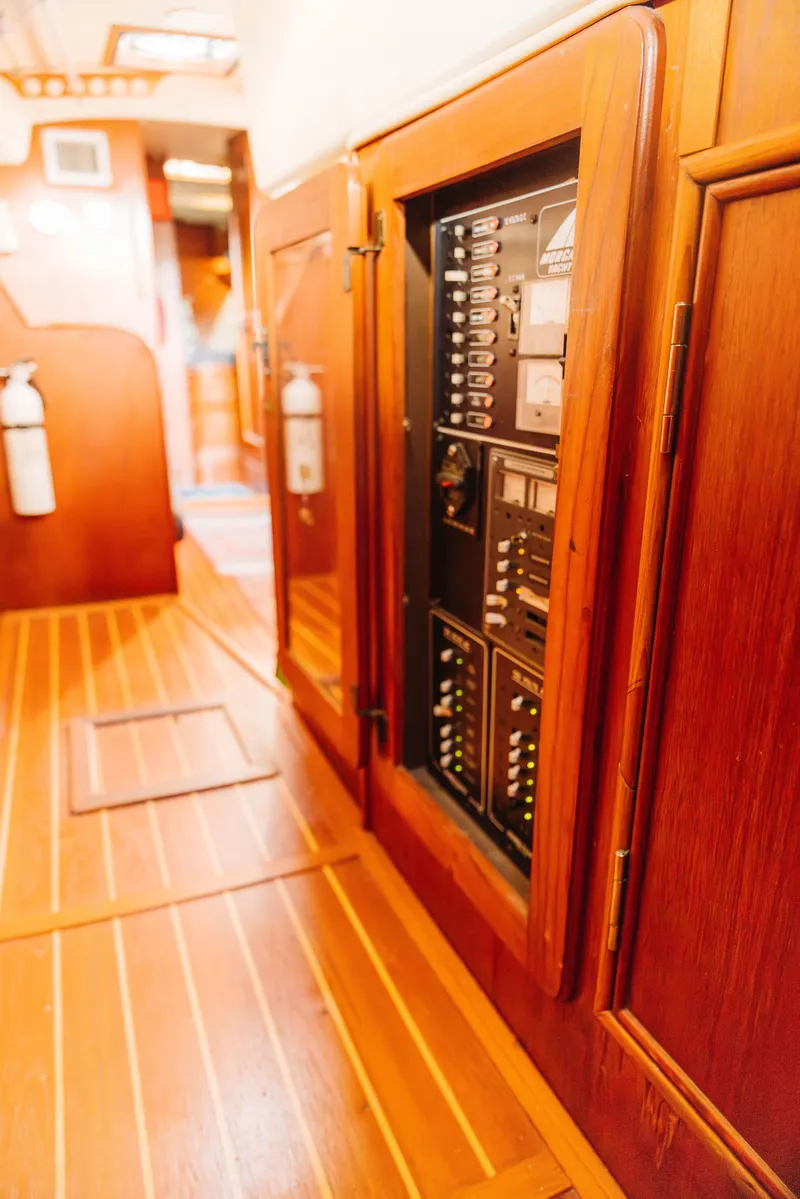 Slide: The Image of 1983 Morgan Out Island 41 yacht interior with wooden paneling and electrical control panel. - 14