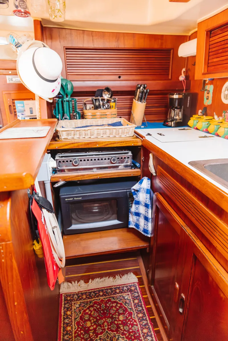 Slide: The Image of 1983 Morgan Out Island 41 yacht kitchen with wood cabinetry, oven, and nautical decor. - 15