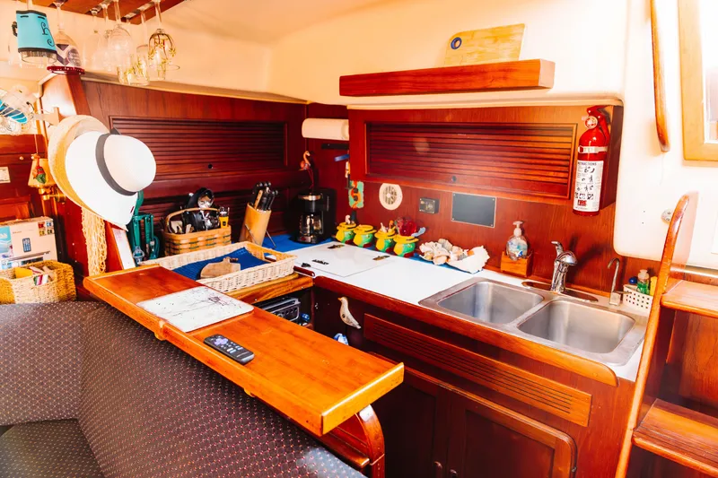 Slide: The Image of 1983 Morgan Out Island 41 yacht interior with wooden cabinetry, kitchen sink, and nautical decor. - 16