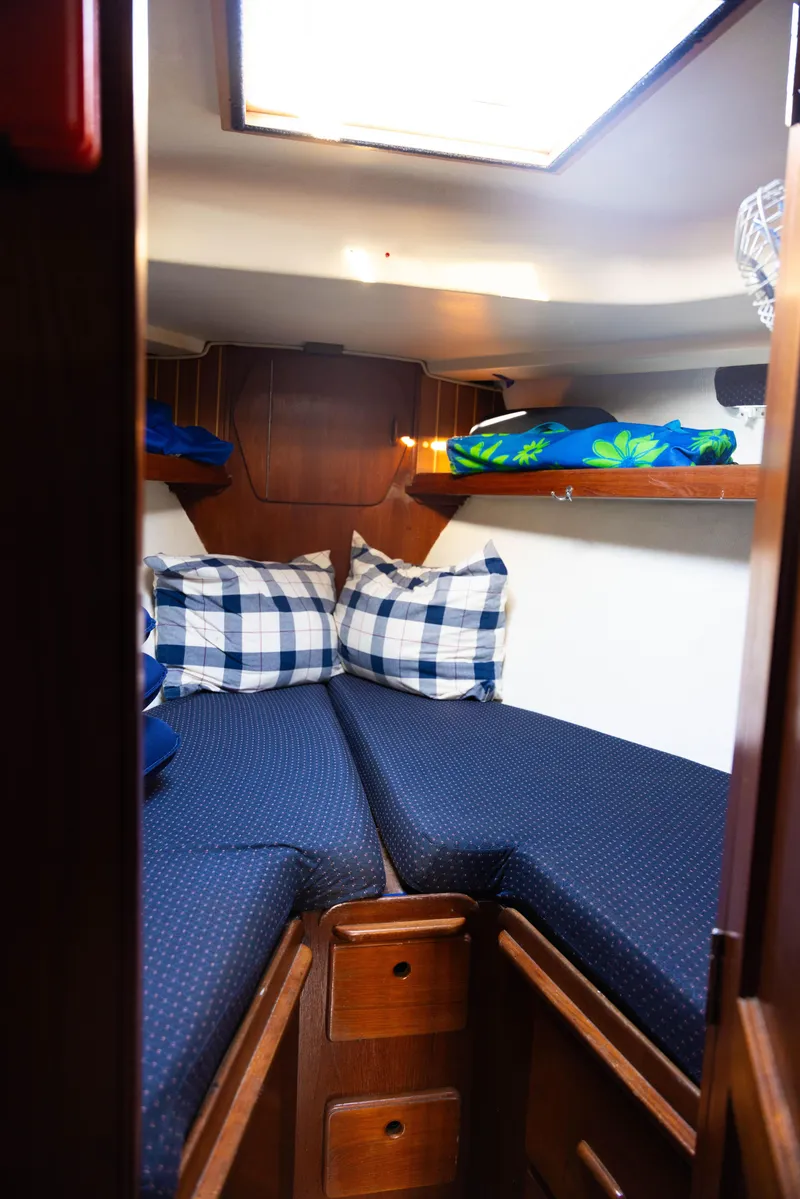 Slide: The Image of 1983 Morgan Out Island 41 cabin interior with cozy bedding and wooden storage. - 19