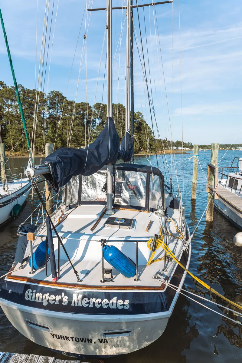 Slide: The Image of 1983 Morgan Out Island 41 sailboat docked in Yorktown, VA, with clear skies and calm waters. - 2