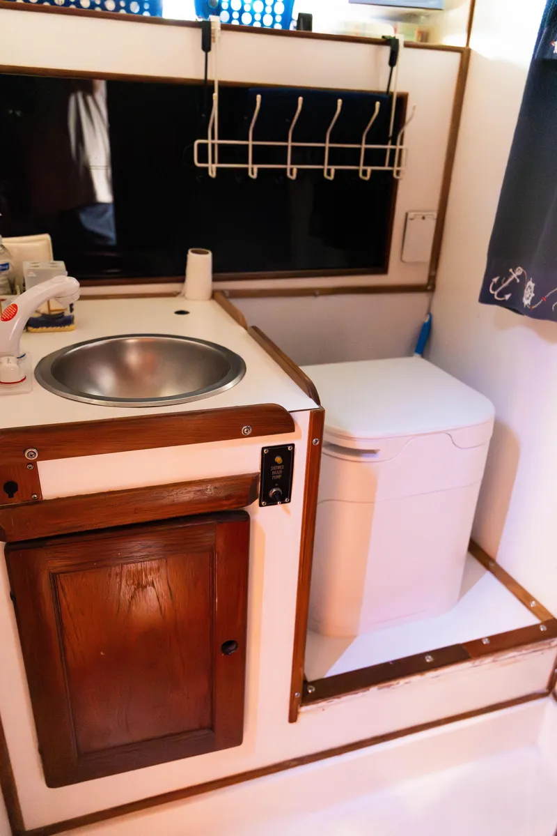 Slide: The Image of 1983 Morgan Out Island 41 yacht bathroom with sink, toilet, and wooden cabinetry. - 21