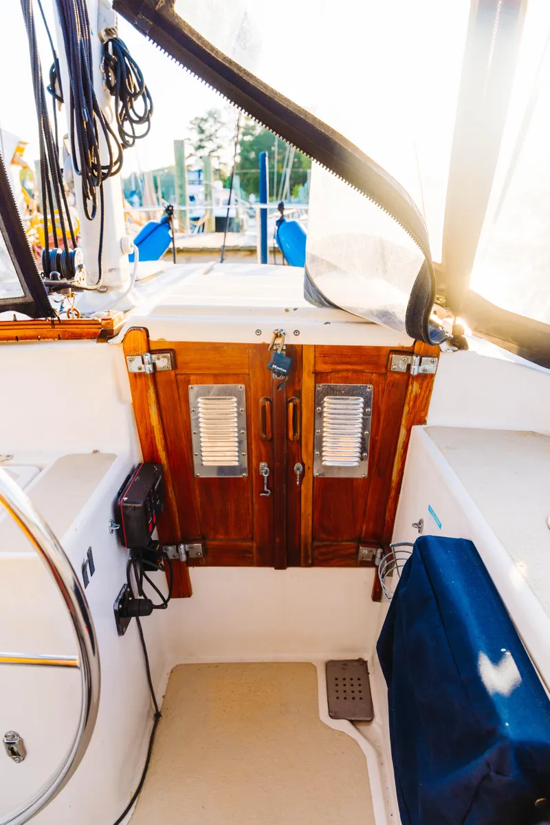 Slide: The Image of 1983 Morgan Out Island 41 sailboat cockpit with wooden doors and nautical equipment. - 25