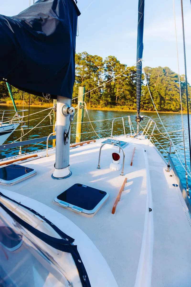 Slide: The Image of 1983 Morgan Out Island 41 sailboat deck with scenic water and trees in the background. - 27