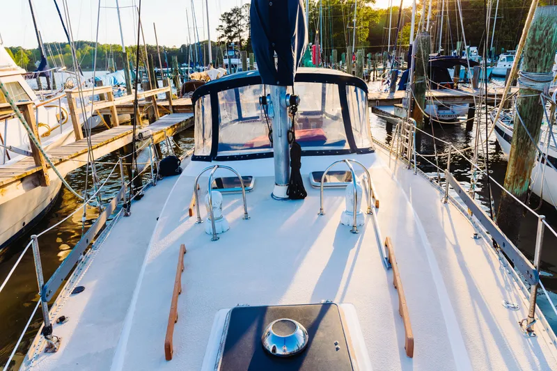 Slide: The Image of 1983 Morgan Out Island 41 sailboat docked at a marina, sunlit deck view. - 29