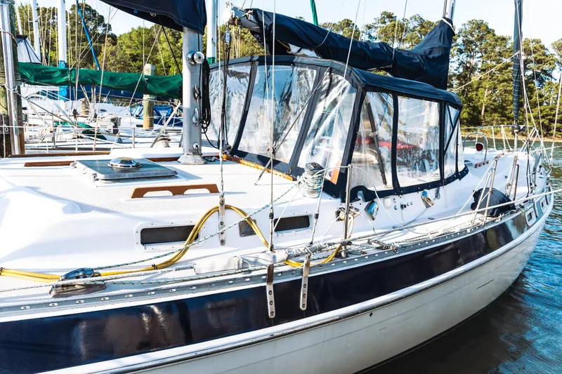 Slide: The Image of 1983 Morgan Out Island 41 sailboat docked at marina, featuring clear cockpit enclosure. - 3