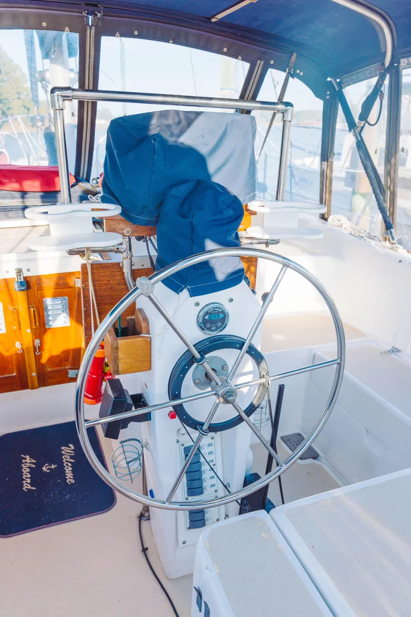 Slide: The Image of 1983 Morgan Out Island 41 sailboat cockpit with steering wheel and covered controls. - 7