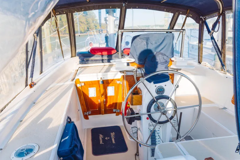 Slide: The Image of 1983 Morgan Out Island 41 sailboat cockpit with steering wheel and navigation equipment. - 9