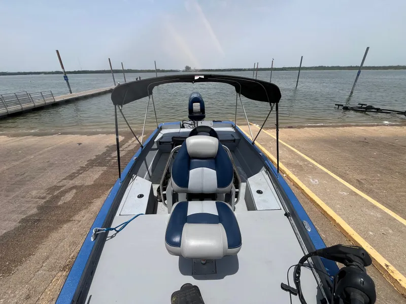Slide: The Image of 2017 G3 20 CCJ DLX boat at a lakeside dock with blue and gray seating. - 14