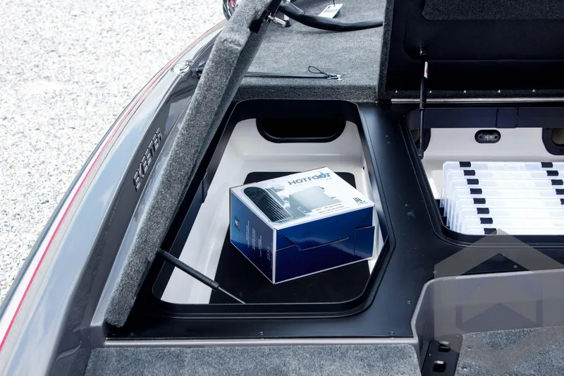 Slide: The Image of Open storage compartment in 2025 Skeeter ZXR 21 boat with a box inside. - 23