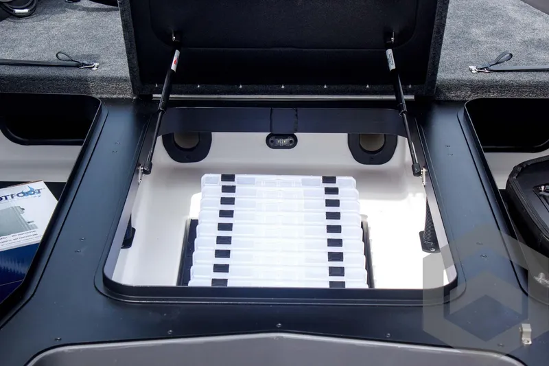 Slide: The Image of Open storage compartment in 2025 Skeeter ZXR 21 boat, showcasing organized tackle boxes. - 24