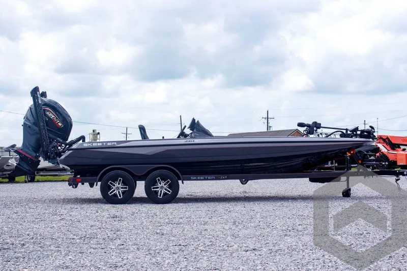 Slide: The Image of 2025 Skeeter ZXR 21 boat on trailer, side view, parked on gravel lot. - 4