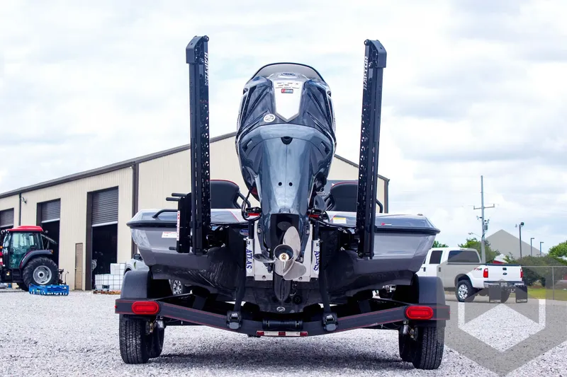 Slide: The Image of 2025 Skeeter ZXR 21 boat rear view, parked on gravel near industrial buildings. - 6