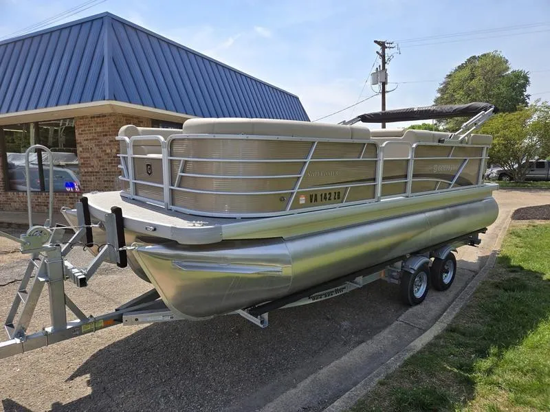 Slide: The Image of 2025 Godfrey Sweetwater 2186 C Sport Tube pontoon boat on trailer, parked outdoors. - 1