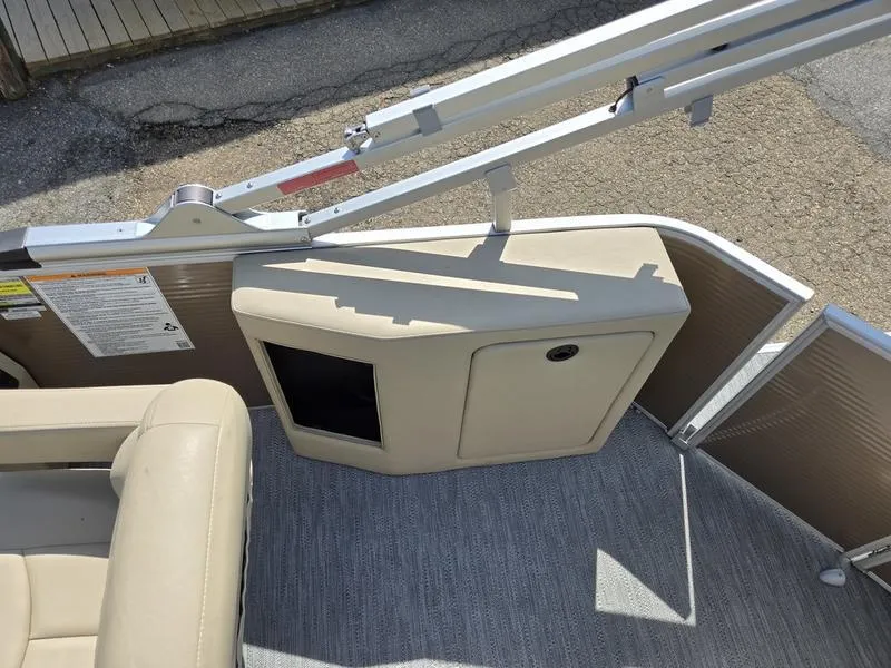 Slide: The Image of 2025 Godfrey Sweetwater 2186 C Sport Tube interior with beige seating and storage compartment. - 10