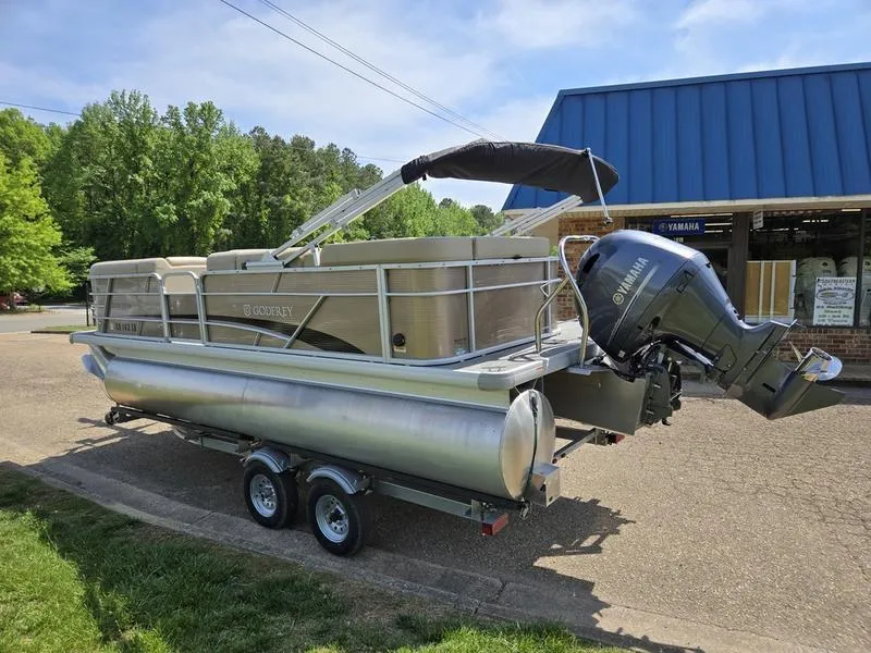Slide: The Image of 2025 Godfrey Sweetwater 2186 C Sport Tube pontoon boat on trailer, parked outdoors. - 2