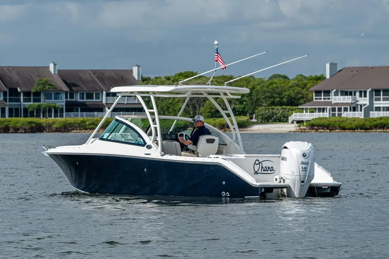 Slide: The Image of 2021 Pursuit DC 246 Dual Console boat on water near residential area. - 14