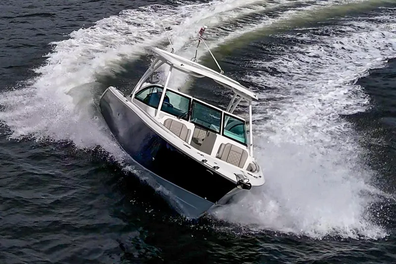 Slide: The Image of 2021 Pursuit DC 246 Dual Console boat navigating through water with dynamic wake. - 18