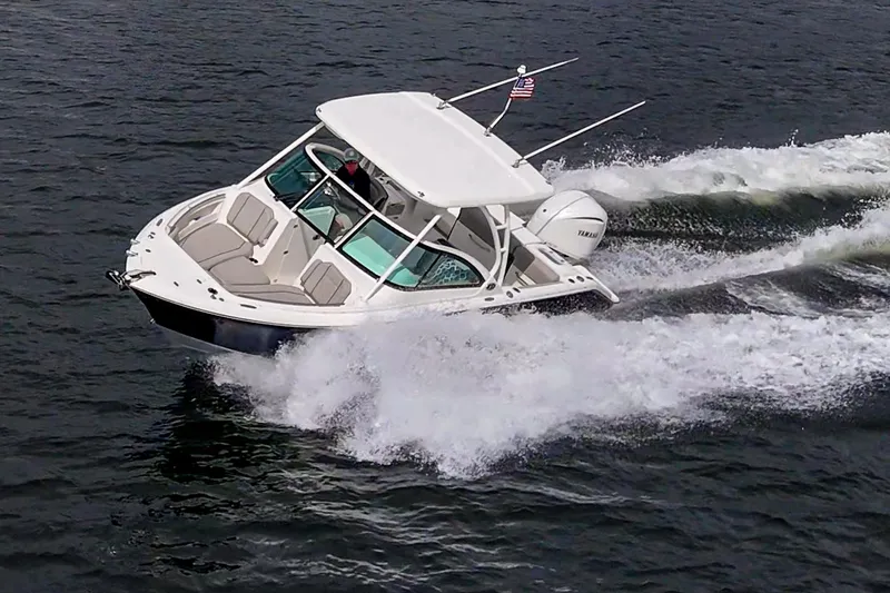 Slide: The Image of 2021 Pursuit DC 246 Dual Console boat cruising on open water. - 19