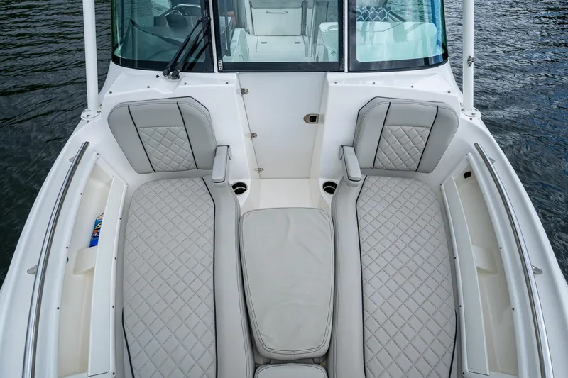 Slide: The Image of 2021 Pursuit DC 246 Dual Console boat interior with cushioned seating on water. - 26