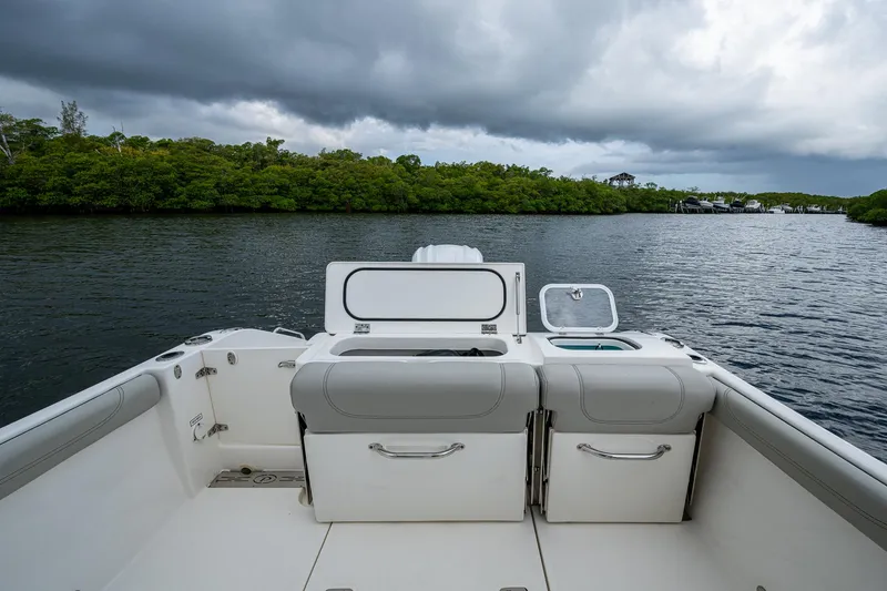 Slide: The Image of 2021 Pursuit DC 246 Dual Console boat on a calm river under cloudy skies. - 27