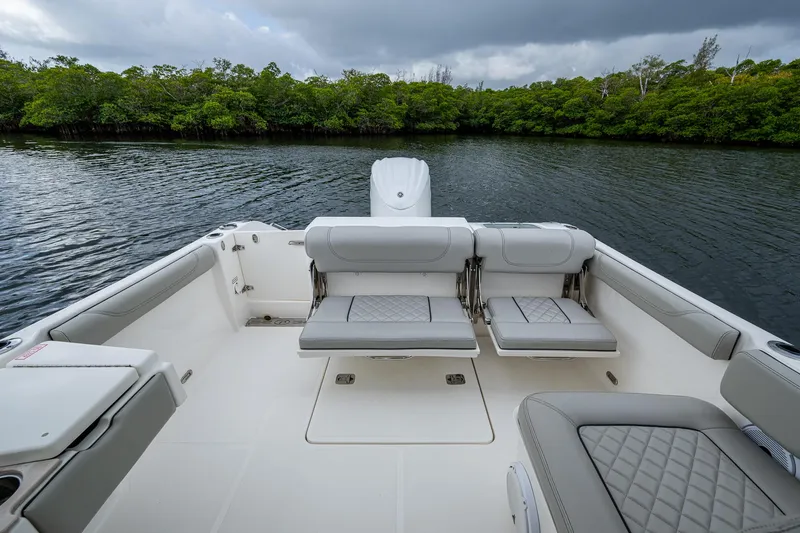 Slide: The Image of 2021 Pursuit DC 246 Dual Console boat interior with seating, on calm water. - 29