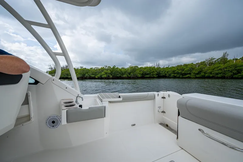 Slide: The Image of 2021 Pursuit DC 246 Dual Console boat interior with scenic water and greenery backdrop. - 31