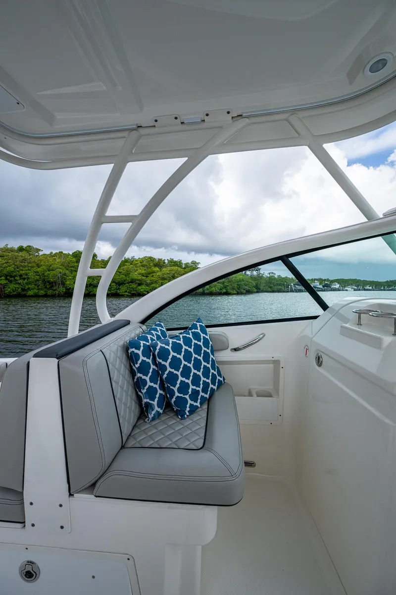 Slide: The Image of 2021 Pursuit DC 246 Dual Console boat interior with cushioned seating and scenic water view. - 39