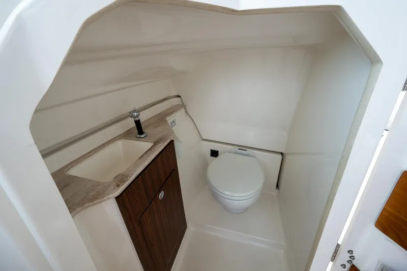 Slide: The Image of 2021 Pursuit DC 246 Dual Console boat interior with compact bathroom and sink. - 40