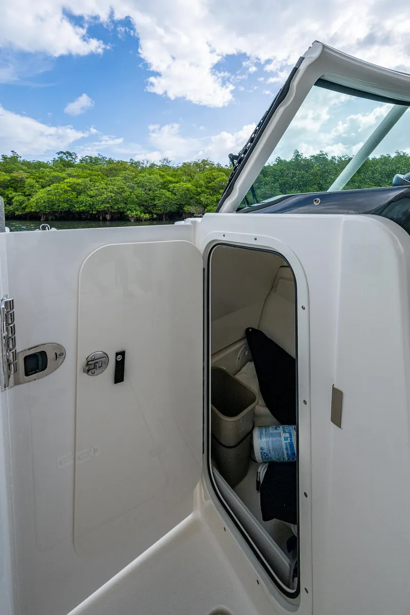 Slide: The Image of 2021 Pursuit DC 246 Dual Console boat interior with open storage compartment. - 41
