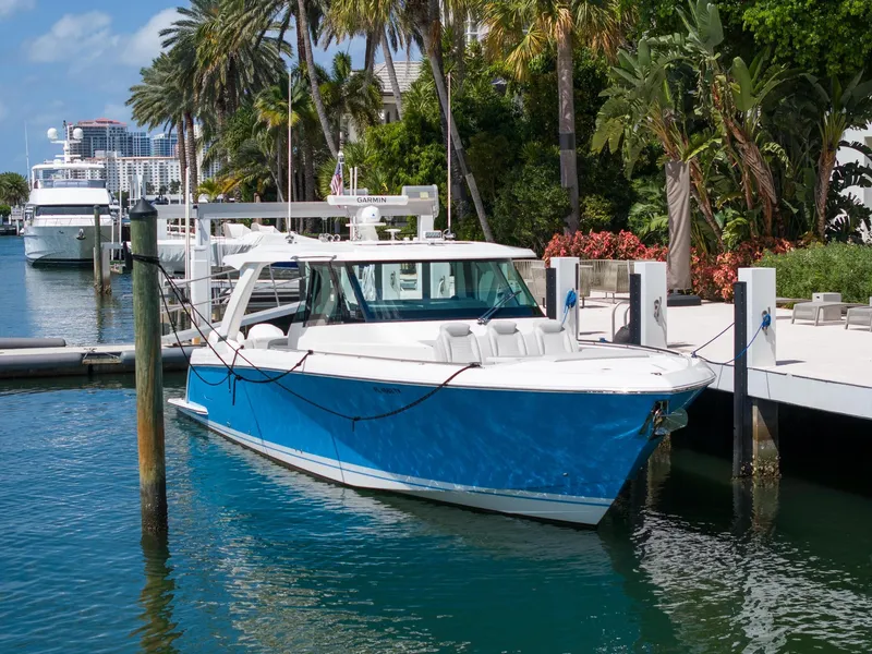 Slide: The Image of 2023 Tiara Yachts 48 LS docked, featuring sleek design and vibrant blue hull. - 1