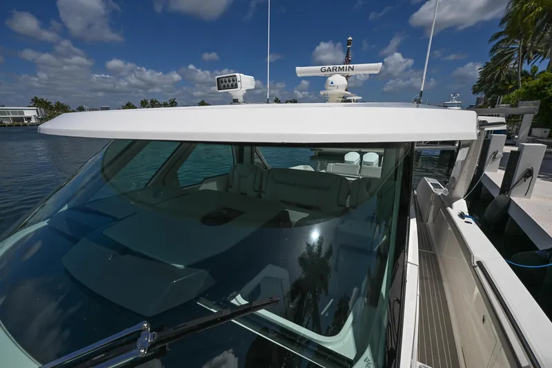 Slide: The Image of 2023 Tiara Yachts 48 LS docked, featuring sleek design and advanced Garmin navigation system. - 16