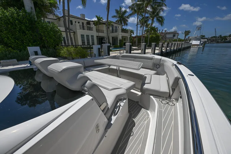 Slide: The Image of 2023 Tiara Yachts 48 LS luxury boat docked by waterfront homes under clear blue skies. - 18