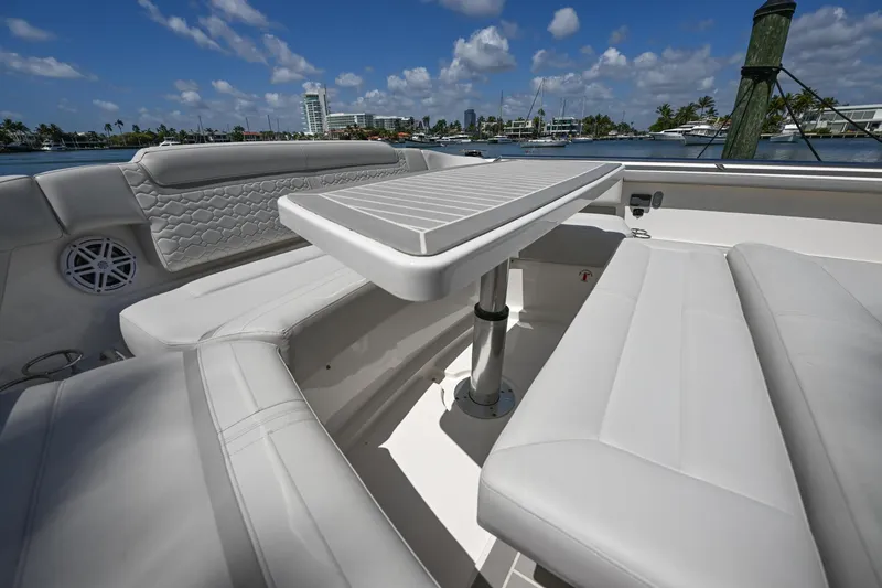 Slide: The Image of 2023 Tiara Yachts 48 LS luxury seating area with table, under clear blue sky. - 20