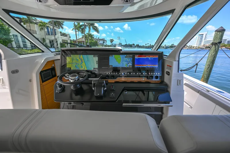 Slide: The Image of 2023 Tiara Yachts 48 LS helm with advanced navigation systems and waterfront view. - 31