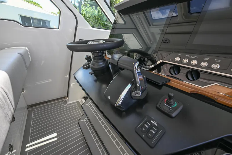 Slide: The Image of Helm of 2023 Tiara Yachts 48 LS with modern controls and steering wheel. - 36