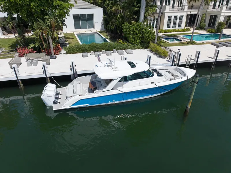 Slide: The Image of 2023 Tiara Yachts 48 LS docked by luxury waterfront homes. - 4