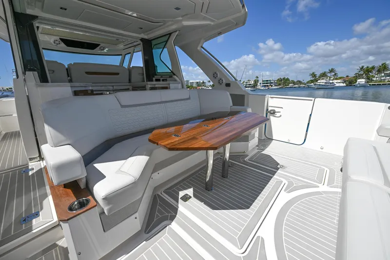 Slide: The Image of 2023 Tiara Yachts 48 LS interior with elegant seating and wooden table, docked by the water. - 43